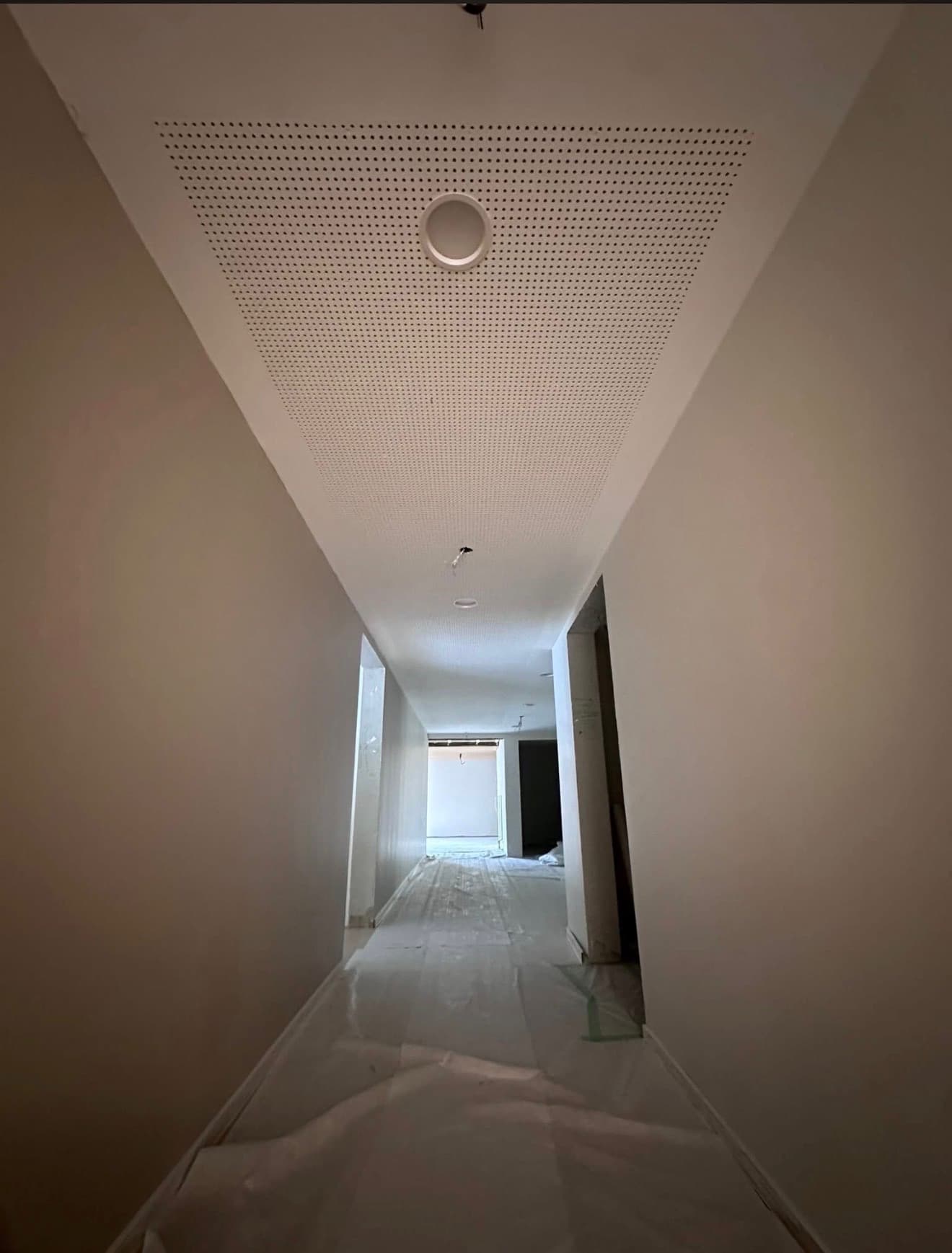 Faux plafond perforé acoustique sur couloir, intégration luminaire circulaire