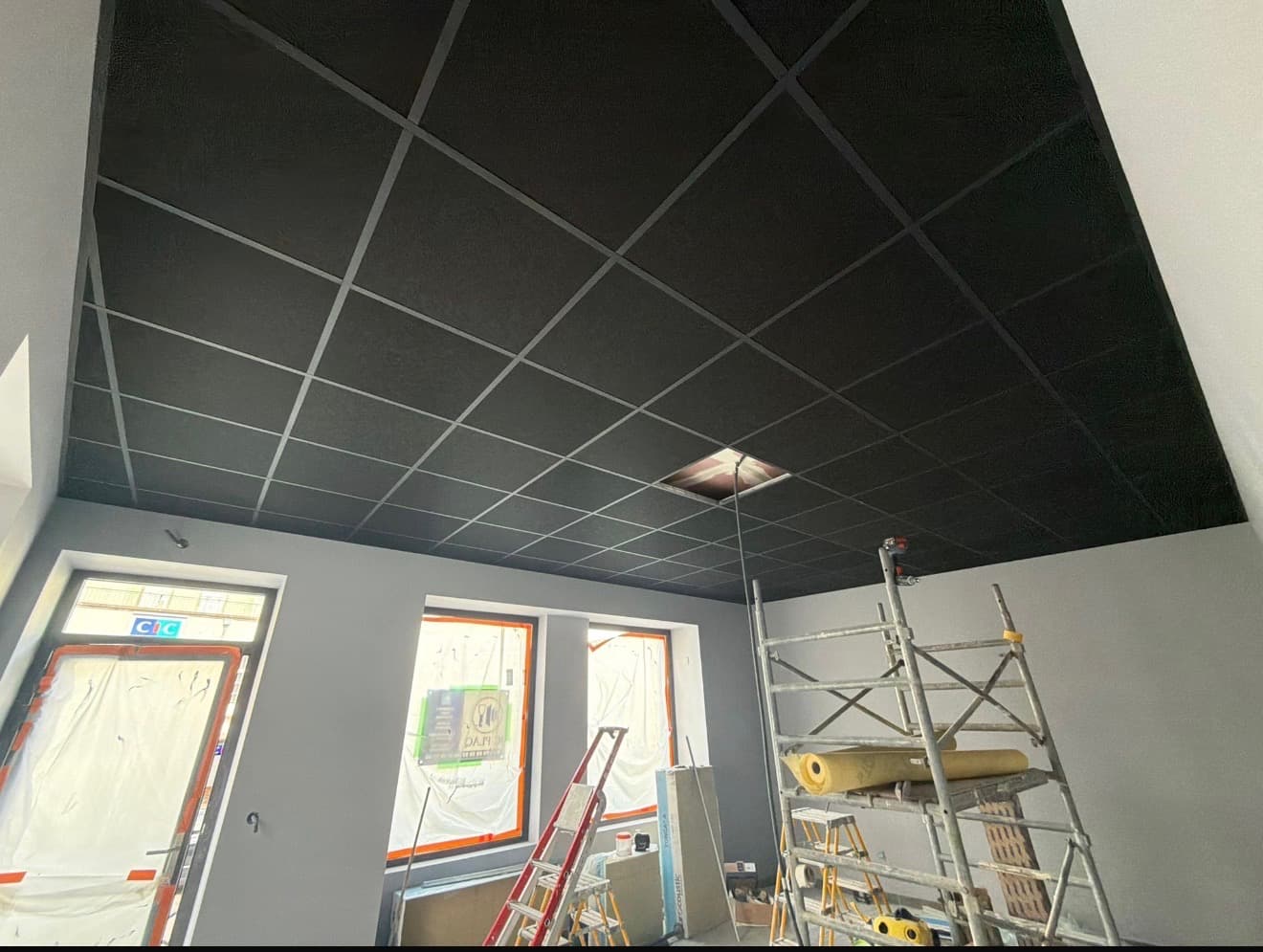 Faux plafond suspendu noir sur agence bancaire en travaux