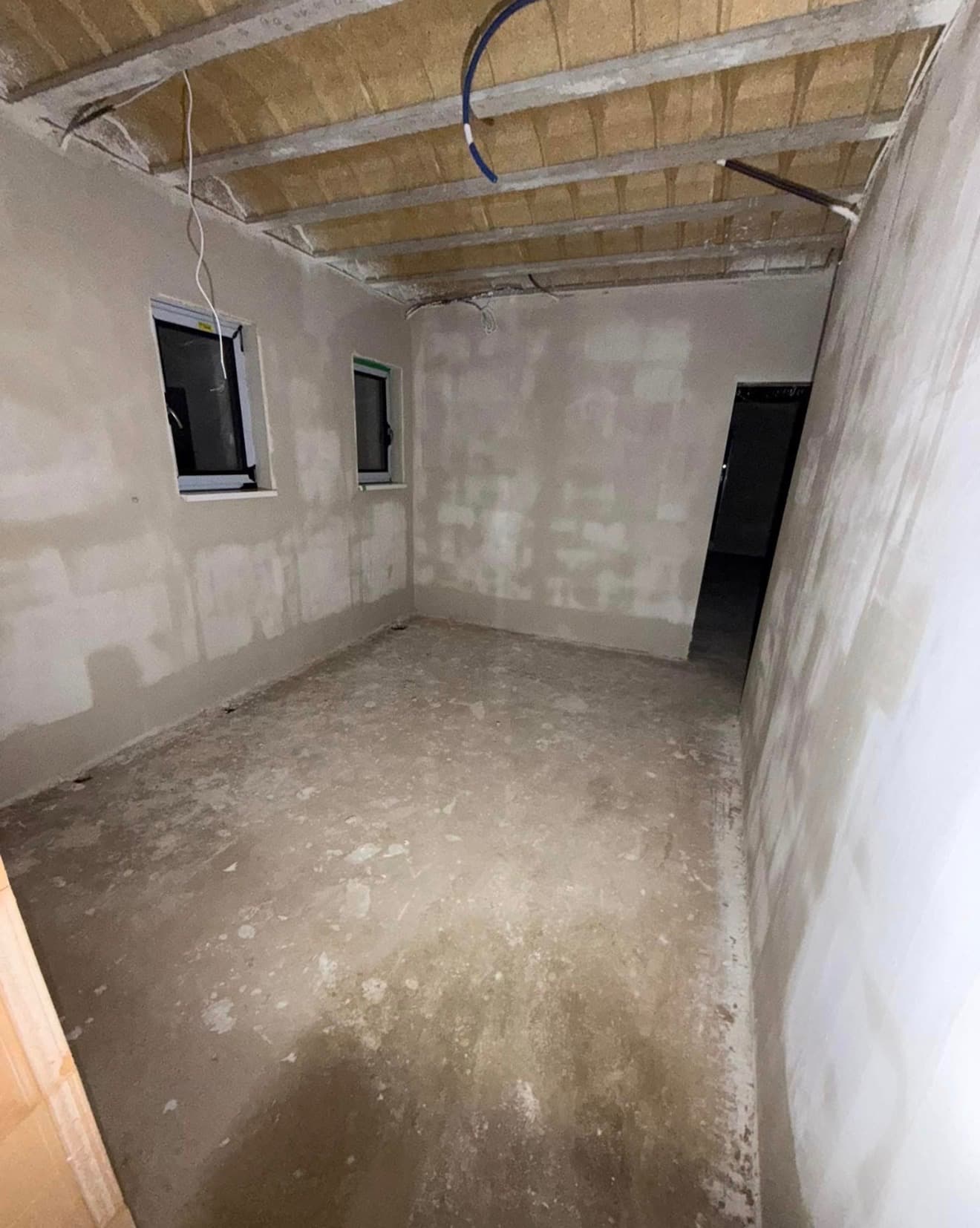 Pièce technique en sous-sol, murs enduits prêts pour isolation
